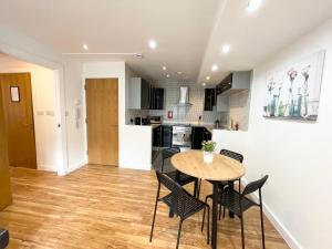 a kitchen and dining room with a table and chairs at The Works-Fresh 2bed in centre, opposite Arndale. in Manchester