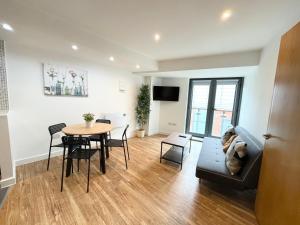 a living room with a table and a couch at The Works-Fresh 2bed in centre, opposite Arndale. in Manchester