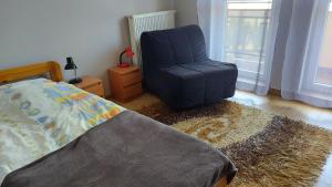 Un dormitorio con una silla azul y una cama en Apartament przy Bulwarze, en Ostróda