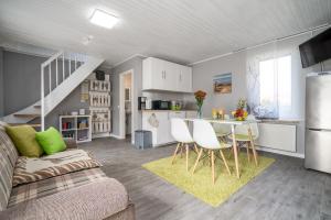 a kitchen and a living room with a table and chairs at FeWo 1 ''Am Rodelberg'' in Priborn