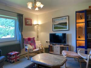 a living room with a television and a table and chairs at Landhaus Schönblick in Radenthein