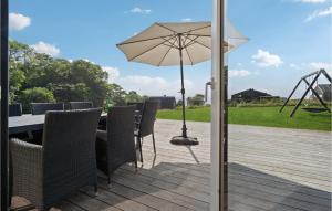 a table and chairs with an umbrella on a deck at Four-Bedroom Holiday Home In Haderslev in Haderslev +19 photos