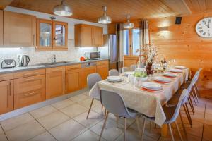a kitchen with a table with chairs and a clock at Chalet Bellanis - OVO Network in Morzine +15 photos