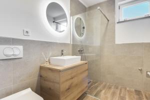 uma casa de banho com um lavatório e um espelho em Chic Apartments with Finnish Sauna and Jacuzzi em Kranjska Gora