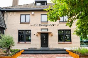 a beige brick building with the words de burgerer at Boutique Hotel de Bungelaer in Beers
