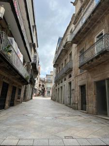 an empty street in an alley between buildings at Corazón casco viejo in Vigo