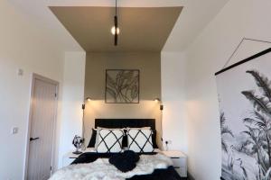 a bedroom with a bed with a black and white pillow at Sophisticated Silcoates in Wakefield