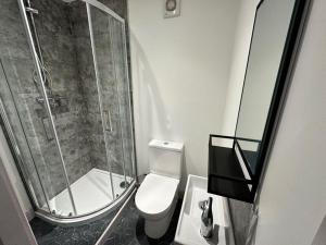 a bathroom with a shower and a toilet and a sink at Sophisticated Silcoates in Wakefield