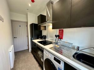 a kitchen with a dishwasher and a sink and a stove at Sophisticated Silcoates in Wakefield