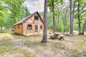 a cabin in the woods with a picnic table at Family Roscommon Home - 3 Mi to Higgins Lake in Roscommon