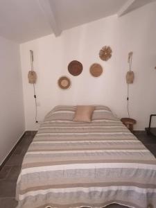 a bed in a bedroom with a white wall at Meublé chaleureux en Provence in Cheval-Blanc