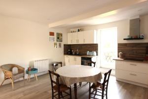 a kitchen and dining room with a table and chairs at Joli appartement avec balcon au coeur de Forcalquier in Forcalquier +3 photos