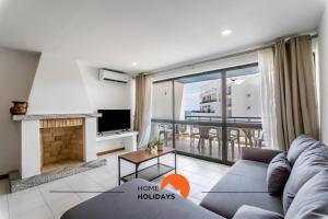 a living room with a couch and a fireplace at #169 T3 Medronheira by Home Holidays in Olhos de Água