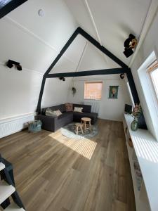 an attic room with a couch and a table at Appartement Oldenburg in Bergen