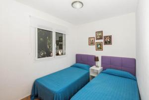 a bedroom with two beds and a window at Villa Palmera in Alaior