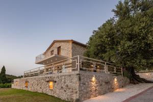 a house on top of a stone wall at Arca Villa - Enchanting Sunset! in Keri