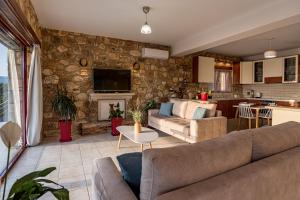 sala de estar con sofá y cocina en Arca Villa - Enchanting Sunset!, en Kerion
