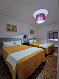 Zimmer mit 2 Betten und einer rosa Decke in der Unterkunft Ricky House Big Waves in Nazaré