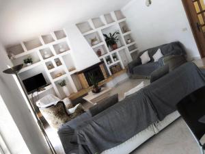 a living room with a couch and a tv at Moradia penina v3 in Portimão