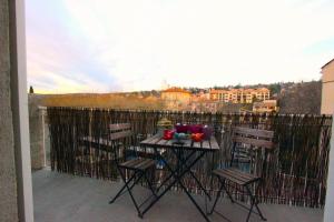 a balcony with a table and chairs on a balcony at Joli appartement avec balcon au coeur de Forcalquier in Forcalquier