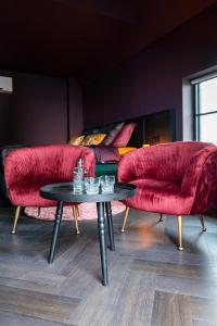 a living room with two red couches and a table at Boutique Hotel de Bungelaer in Beers