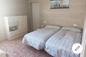 een slaapkamer met een bed en een dressoir bij La casa del pescador in Santa Pola