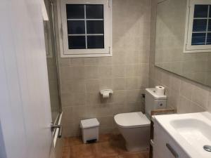 a bathroom with a toilet and a sink and a window at Relax Playa Son Bou, Menorca in Son Bou +17 photos