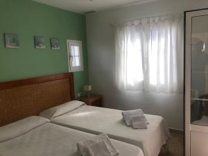 a bedroom with two beds and a window at Relax Playa Son Bou, Menorca in Son Bou