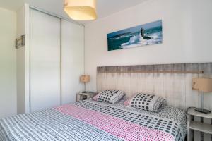 a bedroom with a bed with two pillows on it at Le Kichen - Appt proche de la plage in Bénodet