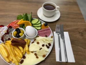 um prato de comida com batatas fritas e uma chávena de café em ACAR SMART OTEL em Arnavutköy