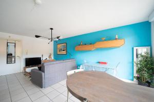 un soggiorno con tavolo e parete blu di La Casa de Cricri - Appartement climatisé a Perpignano