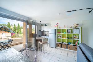 una cucina con frigorifero, tavolo e sedie di La Casa de Cricri - Appartement climatisé a Perpignano
