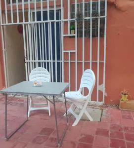 two white chairs and a table on a patio at Zen Studio in Rabat