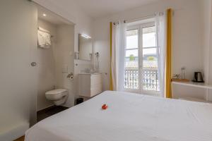 a bedroom with a bed and a toilet and a window at Hôtel & Espace Bien-être La Maison du Lierre in Biarritz
