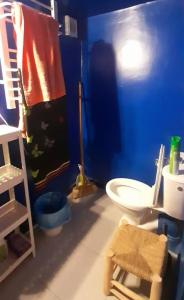 a bathroom with a toilet and a blue wall at Zen Studio in Rabat