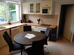 kuchnia z drewnianym stołem i krzesłami oraz stołem w obiekcie Apartment Haus 25 w mieście Velten
