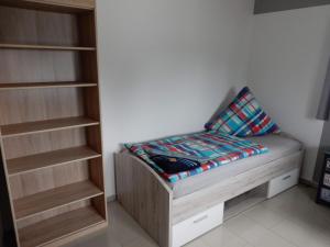 Dormitorio pequeño con cama y estante de libros en Apartment Haus 25 en Velten