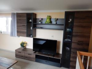 a living room with a large entertainment center with a flat screen tv at Apartment Haus 25 in Velten
