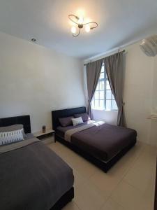 a bedroom with two beds and a window at Dream 1 in Cameron Highlands