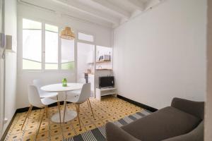 uma pequena sala de estar com uma mesa branca e cadeiras em Rosario 2 em Vinarós