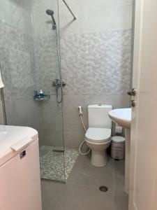 La salle de bains est pourvue d'une douche, de toilettes et d'un lavabo. dans l'établissement Sunny breeze apartment, à Vlorë