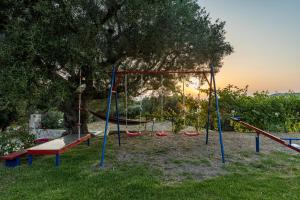 un parque infantil con columpios en Arca Villa - Enchanting Sunset!, en Kerion