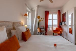 a bedroom with a large bed with orange pillows at Hôtel & Espace Bien-être La Maison du Lierre in Biarritz