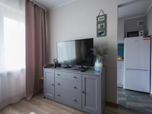 a living room with a television on a white dresser at Dream Team Bocianowo in Bydgoszcz