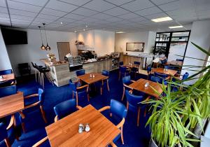 un restaurante con mesas de madera y sillas azules en Sport HOTEL Centrum en Valašské Meziříčí