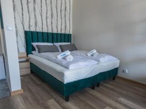 a bed with a green headboard in a room at Dream Team Bocianowo in Bydgoszcz