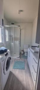 a bathroom with a washing machine and a toilet at Green Turtle Holiday - Lovely, brand new holiday home near the sea in Drage