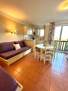 een woonkamer met een bank en een tafel bij Appartement vue mer Golfe de Saint-Tropez in Les Issambres