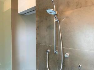 a shower with a shower head in a bathroom at Studio het Strandhuis KA05 in Vlissingen