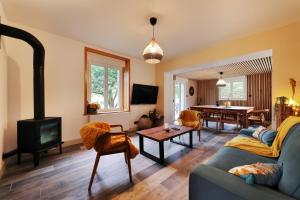 Granit'Home في جوراردُميه: غرفة معيشة مع أريكة ومدفأة